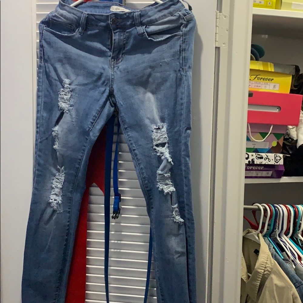 Ripped jeans and blouse over the shoulder
